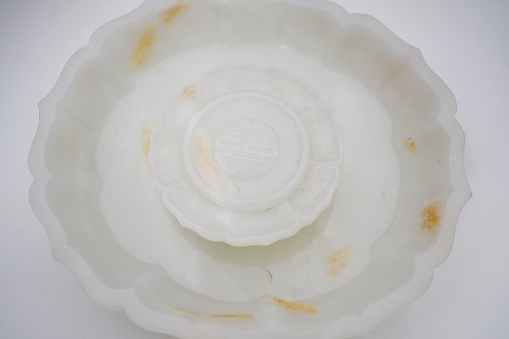 A Chinese white and russet jade petal lobed cup stand